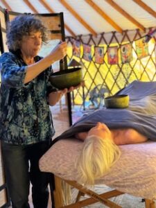 Lynn using singing bowls in massage